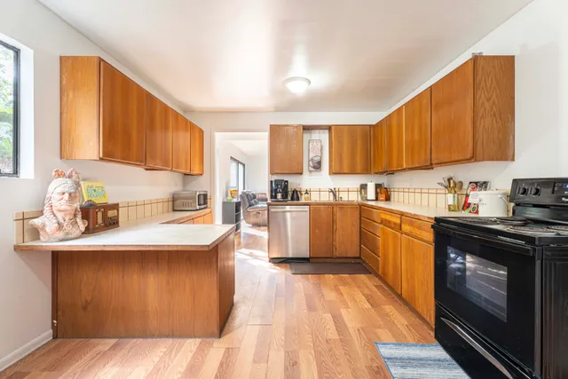 a kitchen with stainless steel appliances granite countertop a stove a sink dishwasher and a refrigerator