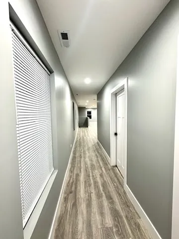 a view of a hallway with wooden floor and staircase