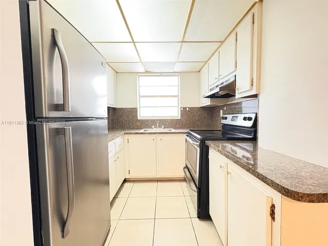 a kitchen with granite countertop a refrigerator and a stove