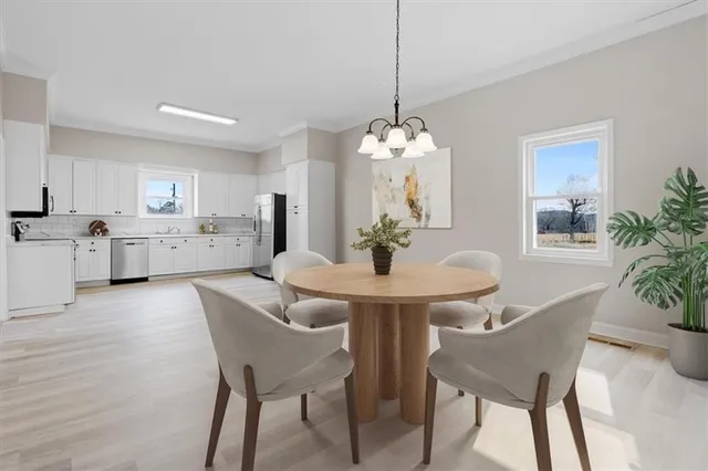 a large kitchen with stainless steel appliances granite countertop a dishwasher a stove a refrigerator white cabinets and wooden floor