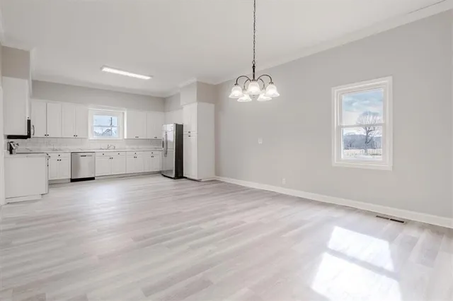 a view of a kitchen with a sink wooden cabinets and refrigerator