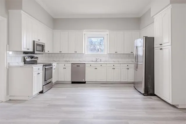 a kitchen with white cabinets stainless steel appliances and sink