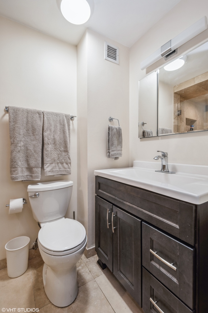 2605 South Indiana Avenue, Unit 1201 Chicago, IL 60616 - Photo 12 of 18 a bathroom with a toilet a sink and mirror