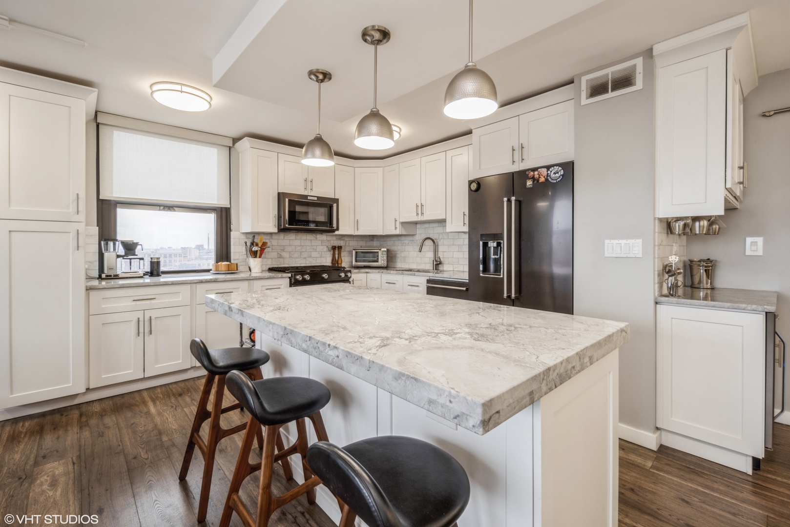 2605 South Indiana Avenue, Unit 1201 Chicago, IL 60616 - Photo 5 of 18 a kitchen with a table chairs refrigerator and microwave