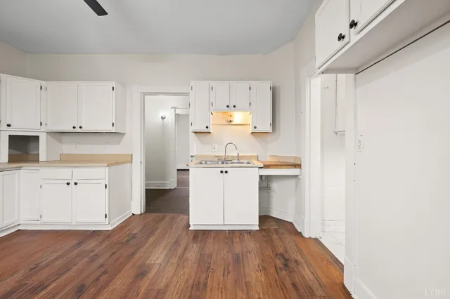 a kitchen with white cabinets and sink