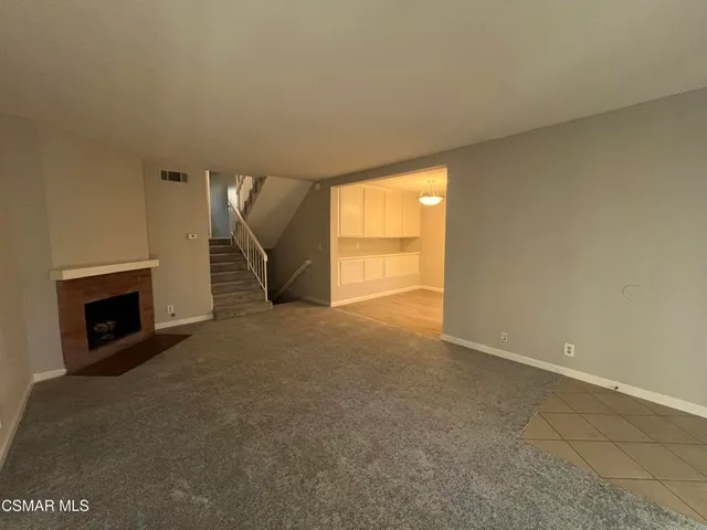 an empty room with a fireplace and window