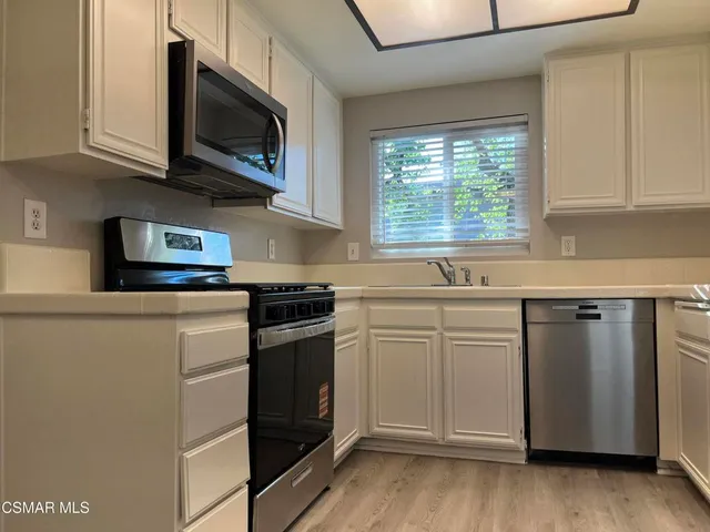 a kitchen with stainless steel appliances granite countertop a sink and a microwave