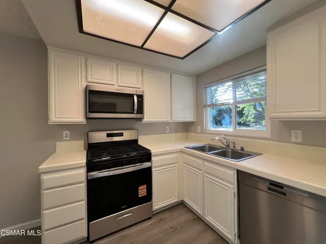 a kitchen with a sink stove and microwave