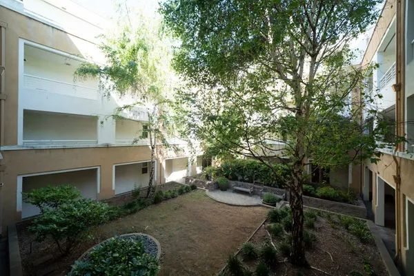 a view of a white house with a yard and potted plants