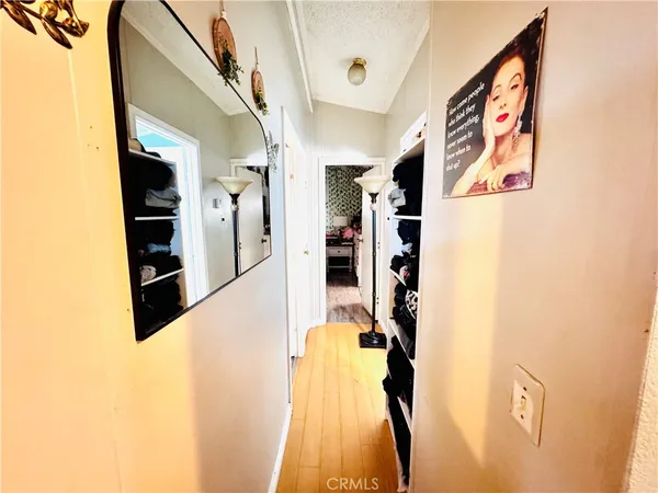 a view of a hallway with wooden floor and stairs