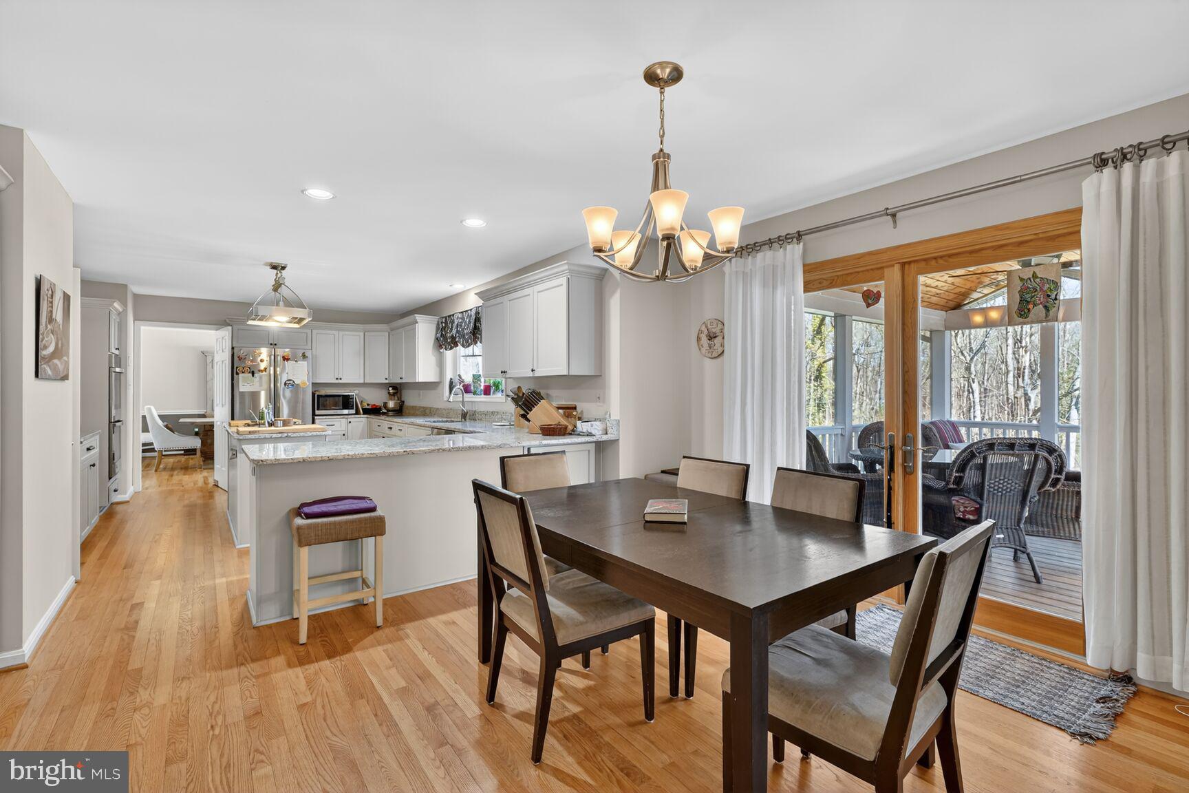 2036 Mayflower Drive Silver Spring, MD 20905 - Photo 12 of 48 a view of a dining room and livingroom with furniture wooden floor a rug a chandelier