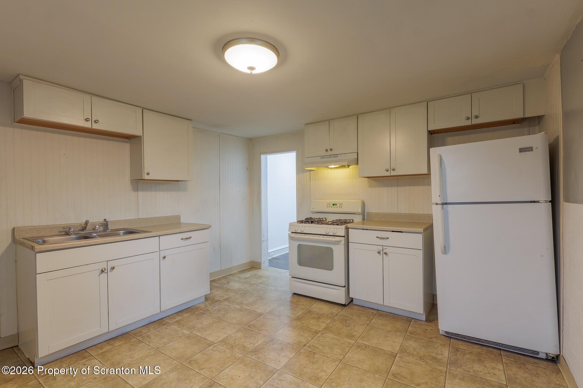 623 East Elm Street, Unit 1 Scranton, PA 18505 - Photo 10 of 15 a kitchen with granite countertop a sink a stove a refrigerator and white cabinets