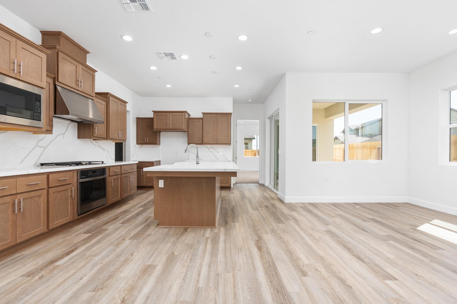 276 Huckleberry Lane South Madera, CA 93636 - Photo 13 of 32 a large kitchen with stainless steel appliances granite countertop a lot of counter space and wooden floors