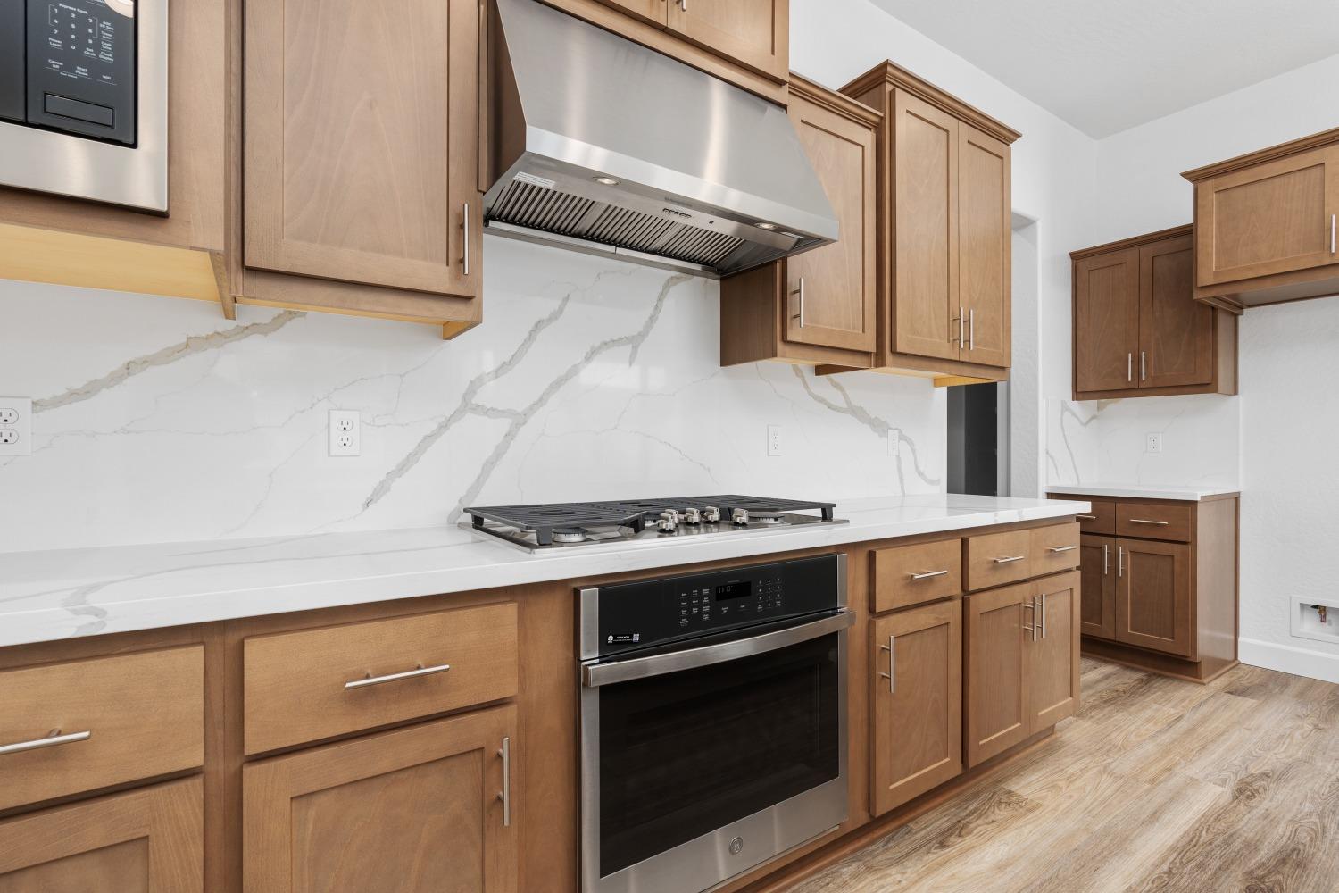 276 Huckleberry Lane South Madera, CA 93636 - Photo 7 of 32 a kitchen with white cabinets and a stove top oven