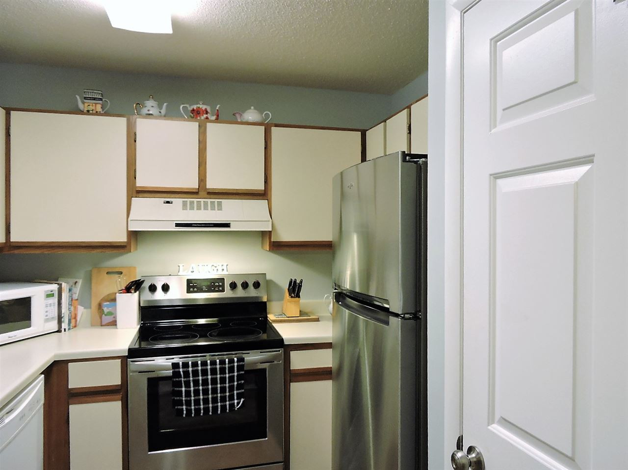 3702 Chimney Ridge Place, Unit 206 Durham, NC 27713 - Photo 6 of 19 a kitchen with stainless steel appliances granite countertop a refrigerator a sink and a stove