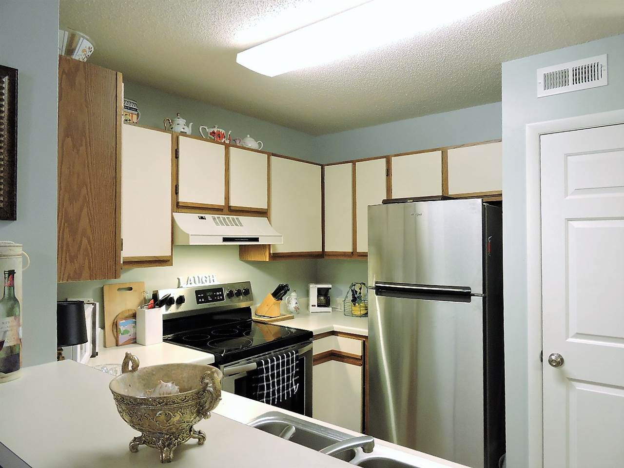 3702 Chimney Ridge Place, Unit 206 Durham, NC 27713 - Photo 8 of 19 a kitchen with stainless steel appliances a refrigerator a stove a sink a microwave and dining table