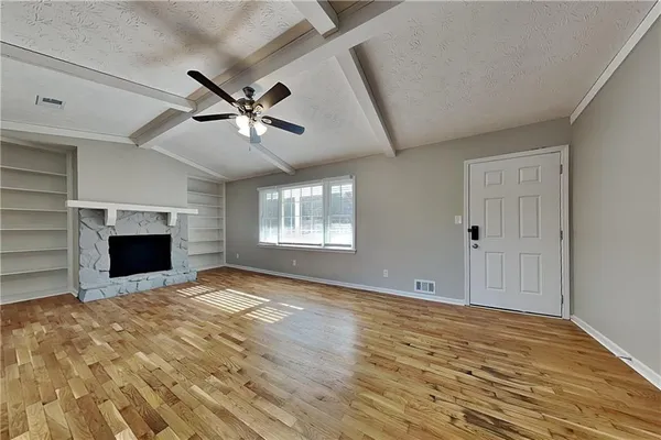 a view of empty room with fireplace and fan