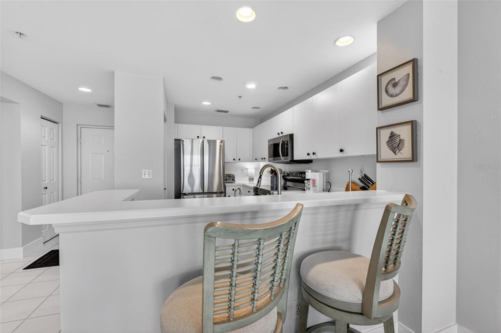 2090 Matecumbe Key Road, Unit 1603 Punta Gorda, FL 33955 - Photo 11 of 47 a kitchen with stainless steel appliances a table and chairs