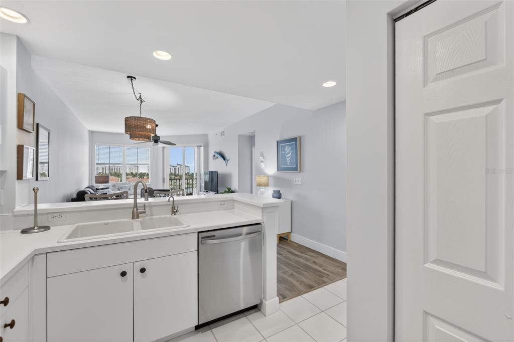 2090 Matecumbe Key Road, Unit 1603 Punta Gorda, FL 33955 - Photo 13 of 47 a kitchen with a sink dishwasher and white cabinets with wooden floor