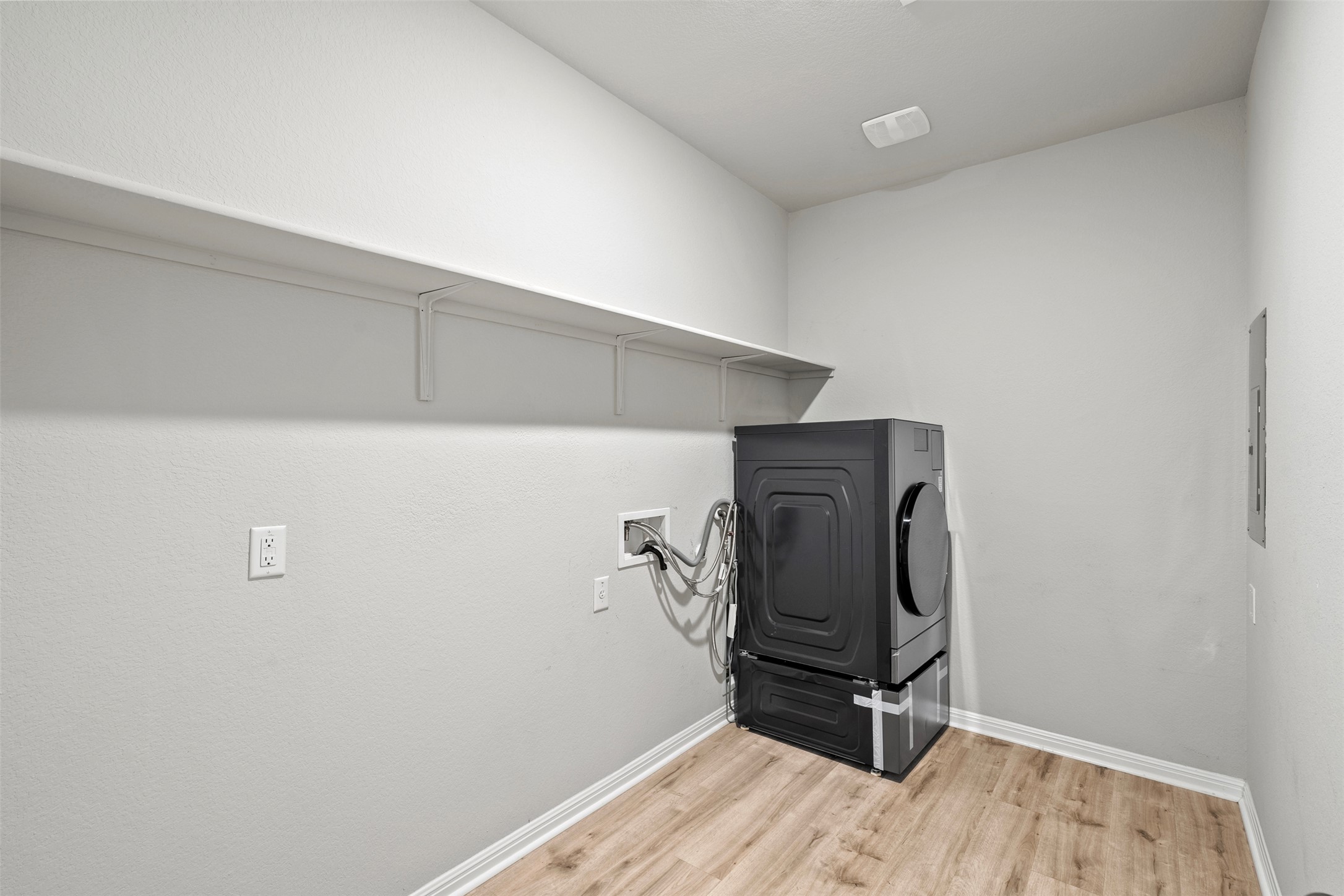 120 Ellinger Road Georgetown, TX 78626 - Photo 16 of 28 Dedicated laundry area featuring wood-finish flooring, white walls, and an overhead storage shelf