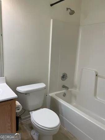 a white toilet and tub sitting next to a bathroom sink