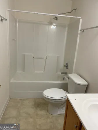 a white toilet sitting next to a bath tub and a shower