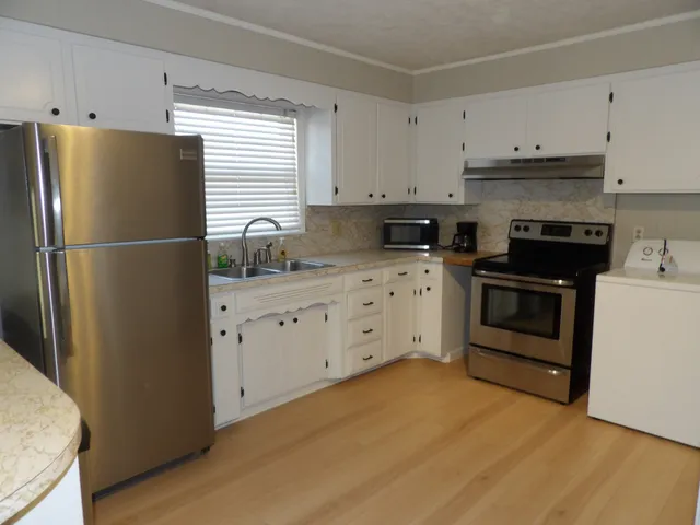 a kitchen with granite countertop a sink and a stove top oven