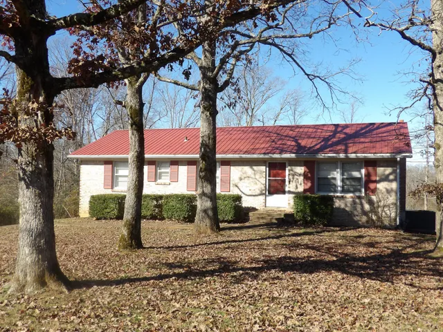 a view of a house with a tree in front of it