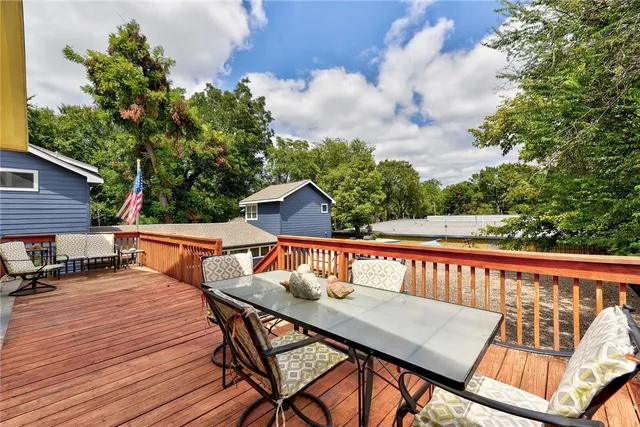 a balcony with wooden floor and outdoor seating