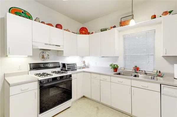 a kitchen with cabinets a sink and appliances
