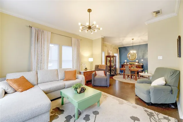 a living room with furniture and a chandelier