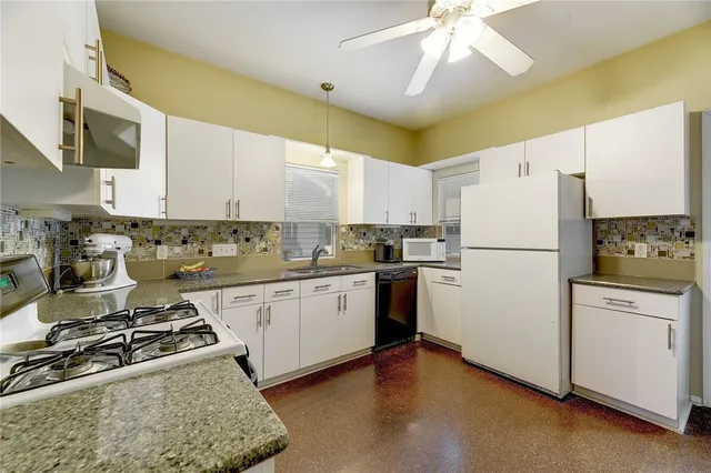 a kitchen with stainless steel appliances granite countertop a refrigerator a stove a sink dishwasher and a refrigerator