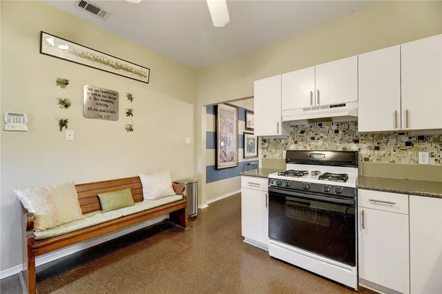 a kitchen with a stove and white cabinets