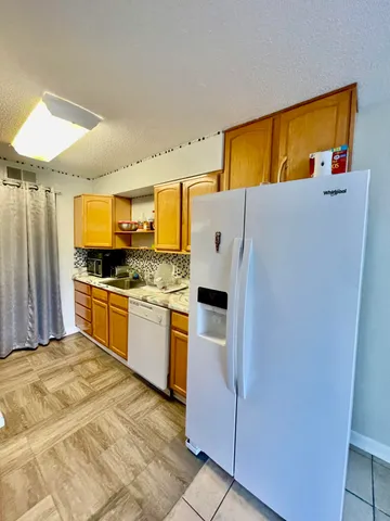 a kitchen with stainless steel appliances kitchen island granite countertop a stove a sink and a refrigerator