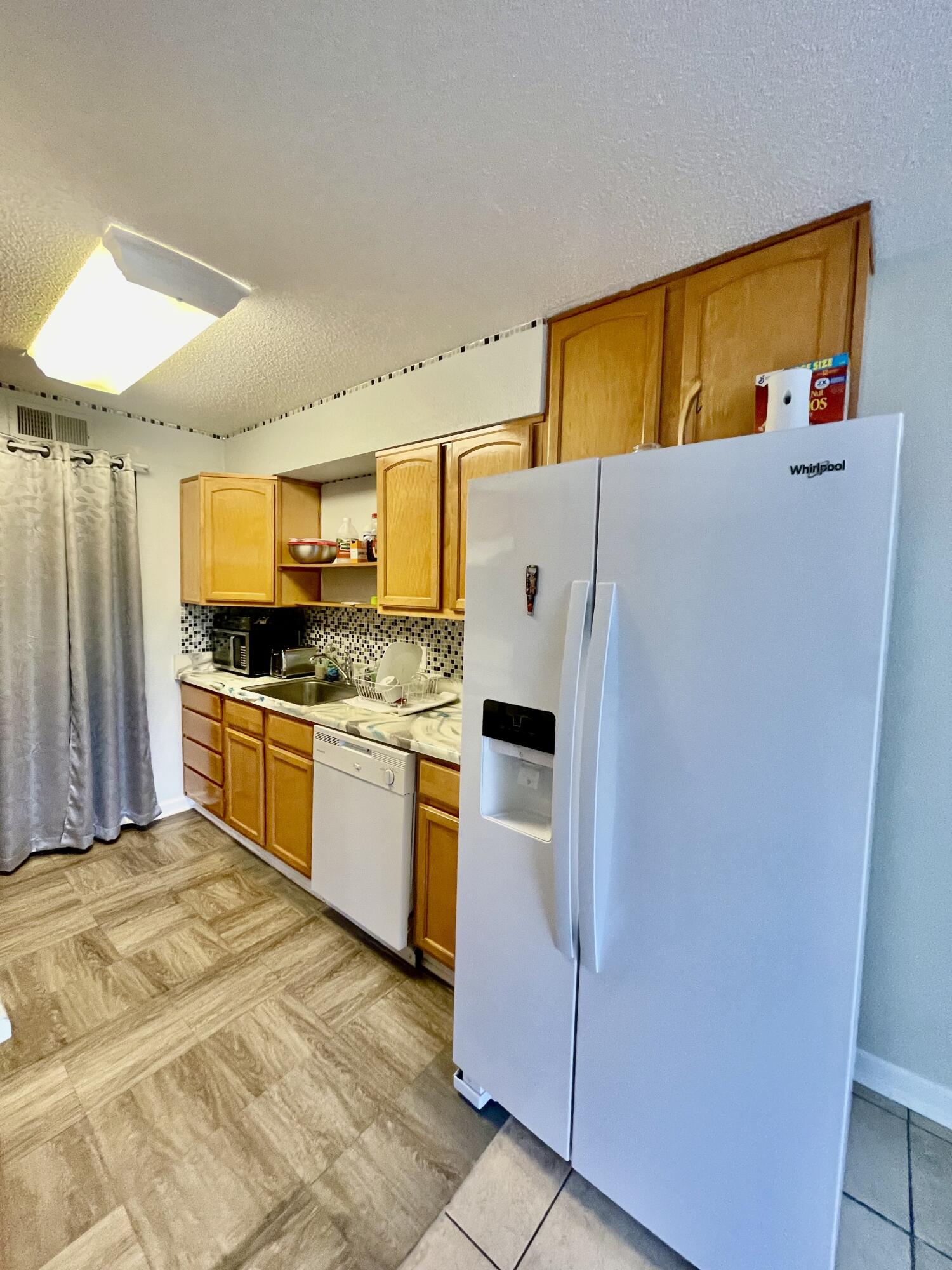 210 Pelham Road, Unit 214A Fort Walton Beach, FL 32547 - Photo 7 of 17 a kitchen with a refrigerator sink and cabinets