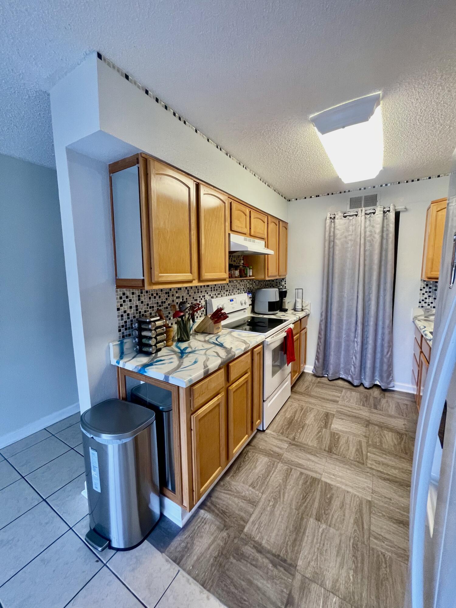 210 Pelham Road, Unit 214A Fort Walton Beach, FL 32547 - Photo 8 of 17 a kitchen with stainless steel appliances granite countertop a stove a sink and a refrigerator
