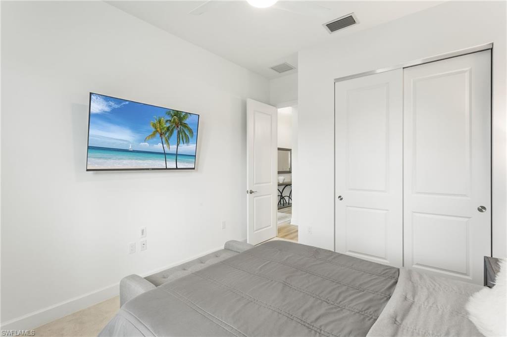 12370 Purple Ficus Way Naples, FL 34120 - Photo 25 of 50 Bedroom with a ceiling fan, light colored carpet, and a closet