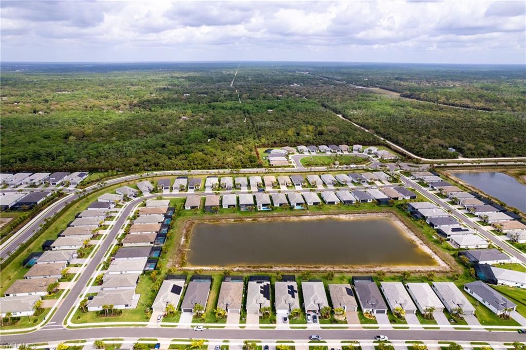 12370 Purple Ficus Way Naples, FL 34120 - Photo 40 of 50 Aerial view of residential area with a nearby body of water and a forest