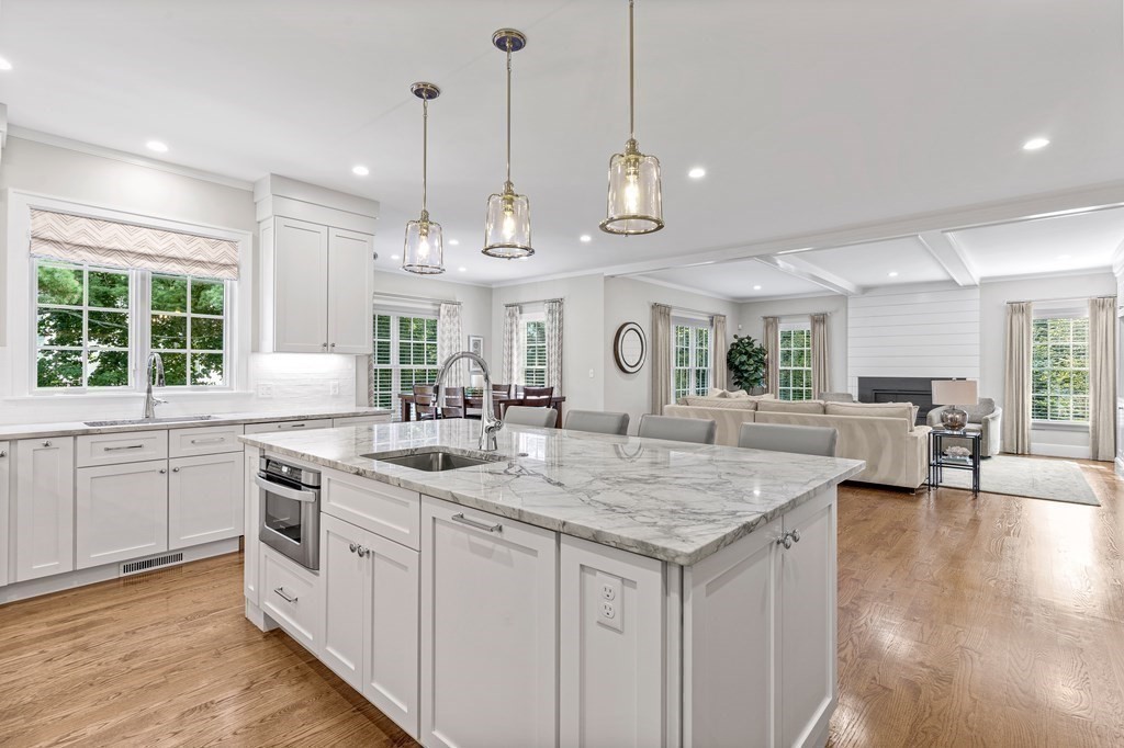 34 Willow Road Wellesley, MA 02482 - Photo 5 of 26 a kitchen with stainless steel appliances granite countertop stove a sink a oven a dining table and chairs with wooden floor