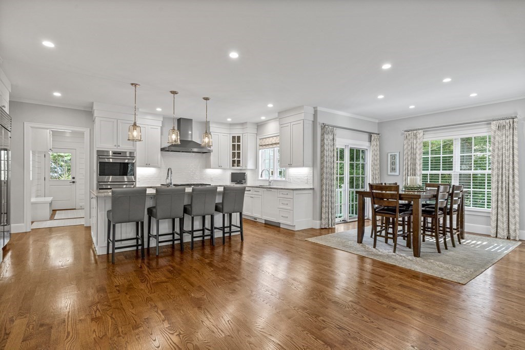 34 Willow Road Wellesley, MA 02482 - Photo 7 of 26 an open kitchen with kitchen island dining table and wooden floor