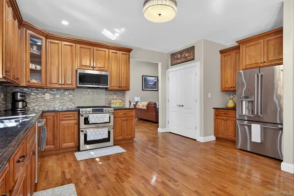 a kitchen with stainless steel appliances granite countertop a refrigerator microwave and sink