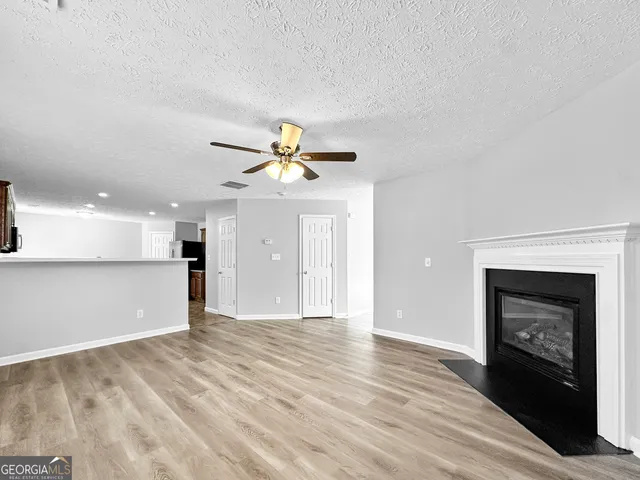a view of empty room with wooden floor and fireplace