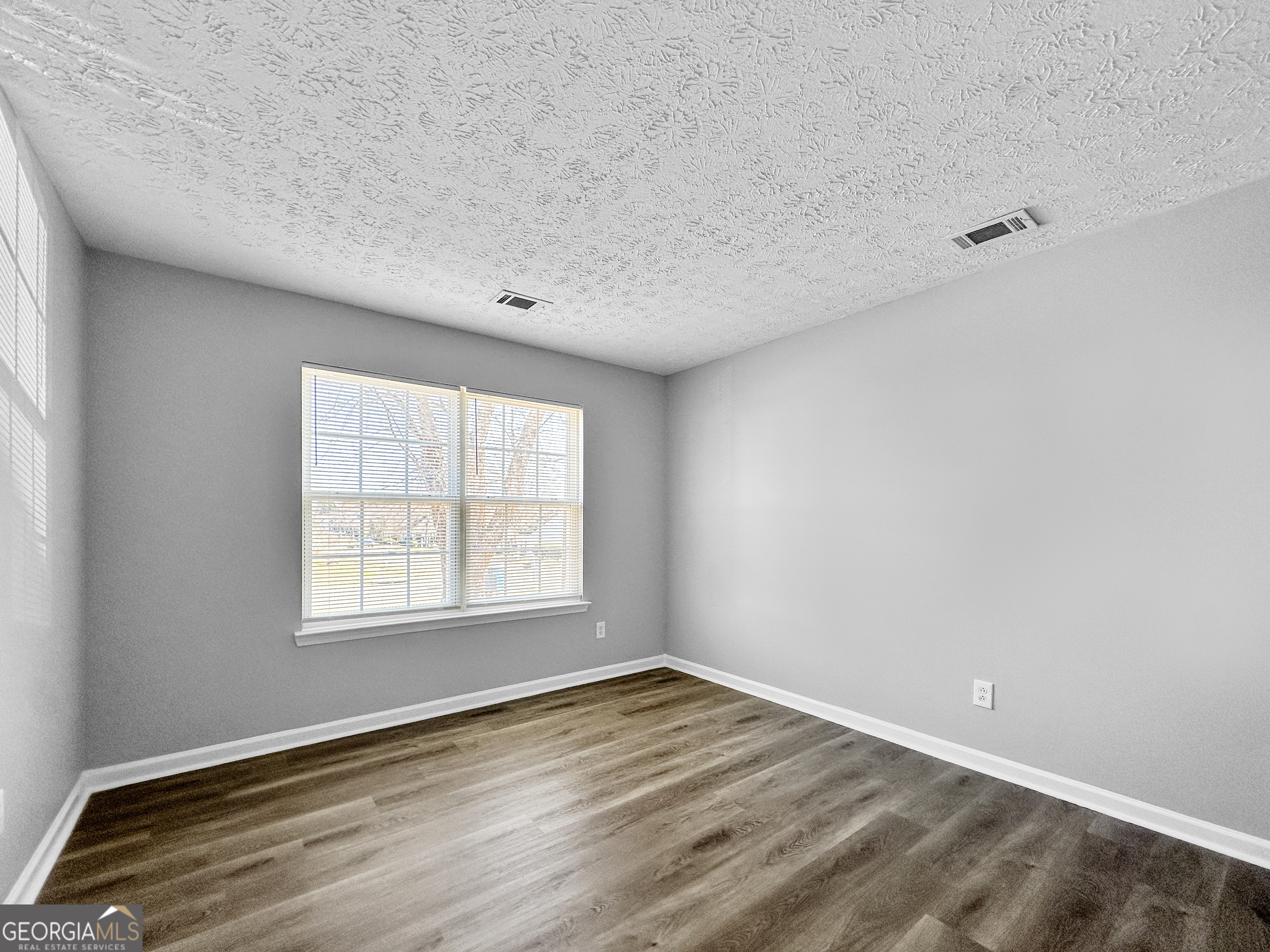 4045 Springvale Way McDonough, GA 30252 - Photo 5 of 18 an empty room with wooden floor and windows