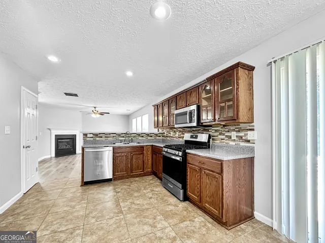 a kitchen with stainless steel appliances granite countertop a stove top oven sink and cabinets