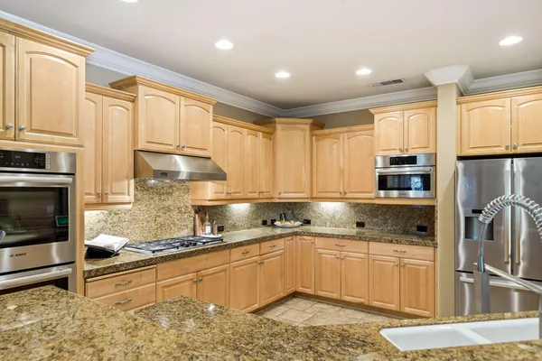 a kitchen with stainless steel appliances granite countertop a refrigerator sink and cabinets