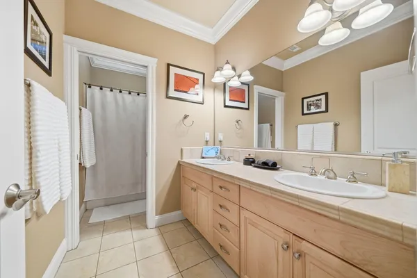 a spacious bathroom with a double vanity sink a mirror a and a shower