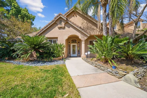 a view of a white house with a yard and potted plants