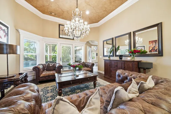 a living room with furniture and a chandelier