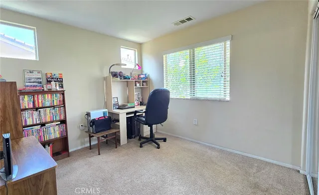 a view of a workspace with furniture and a window