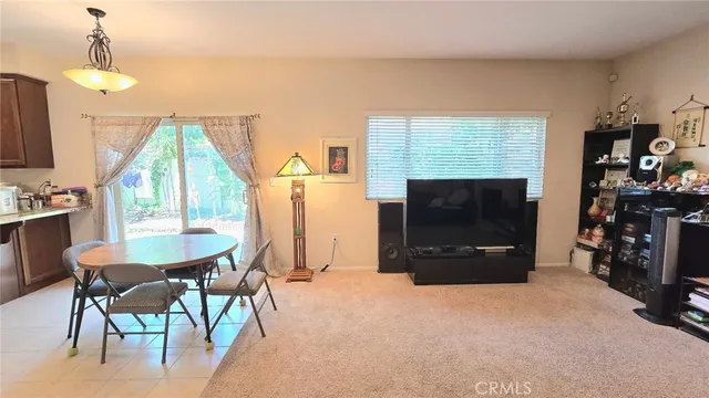 a living room with furniture a flat screen tv and a window